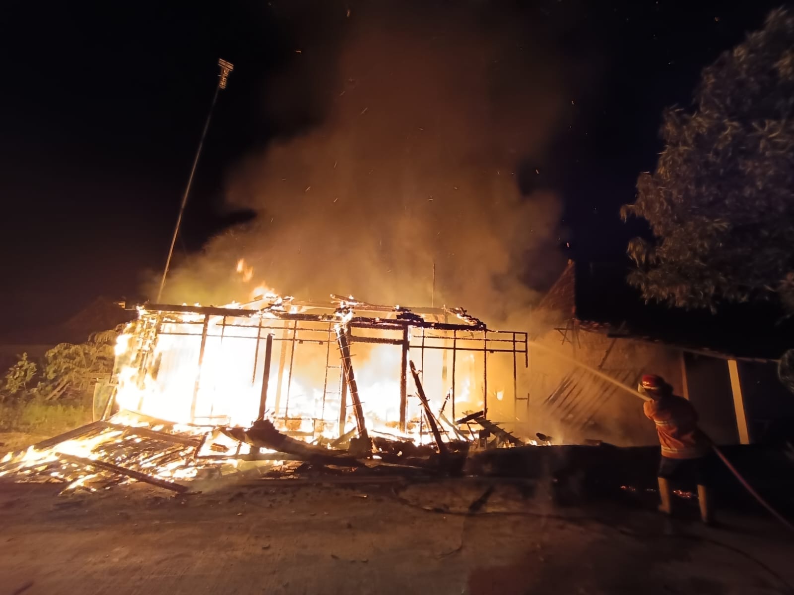 JINAKAN API: Petugas pemadam kebakaran memadamkan kobaran api yang membakar rumah warga Ngadem Rembang kemarin malam.