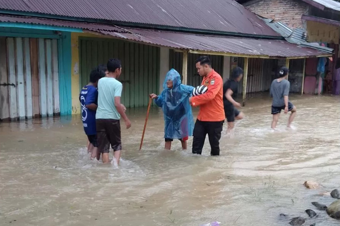 Petugas BPBG mengevakuasi lansia yang terjebak banjir di wilayah Kabupaten padang PAriaman, Sumatra Barat, Minggu (23/11/2025).