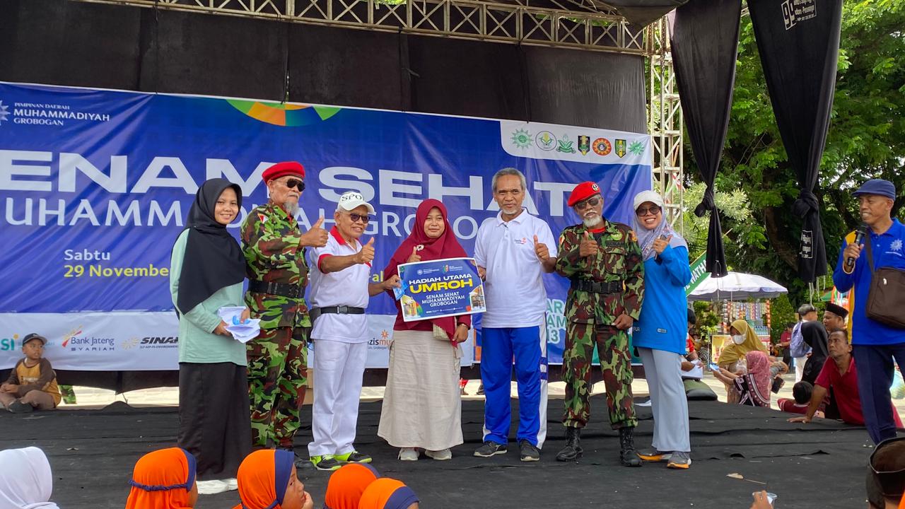 SERAHKAN HADIAH &ndash; Dwi Endrayani guru SD Bilingual Muhammadiyah 1 Purwodadi mendapatkan hadiah dorprize Umroh yang diserahkan Bendahara PDM Muhammadiyah Groogan Jati Purnomo dalam rangka jalan sehat