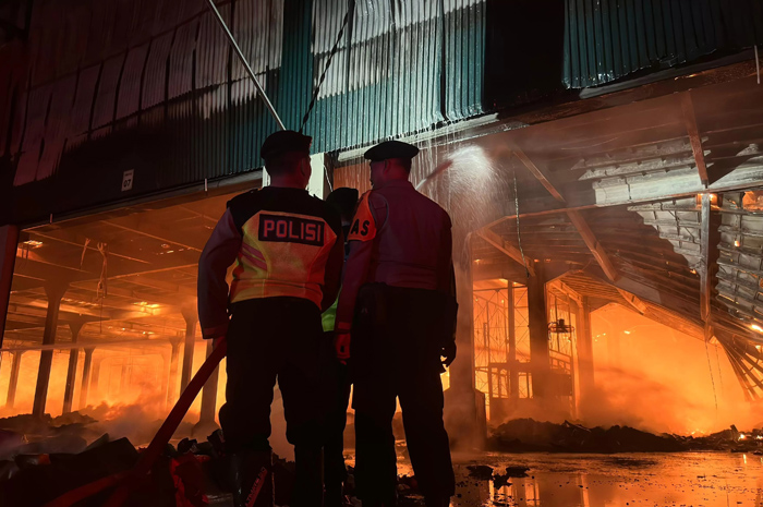 KESULITAN: Personel Polresta Pati membantu pemadaman kebakaran gudang PT Dua Kelinci Pati hingga dini hari (2/12/2025).
