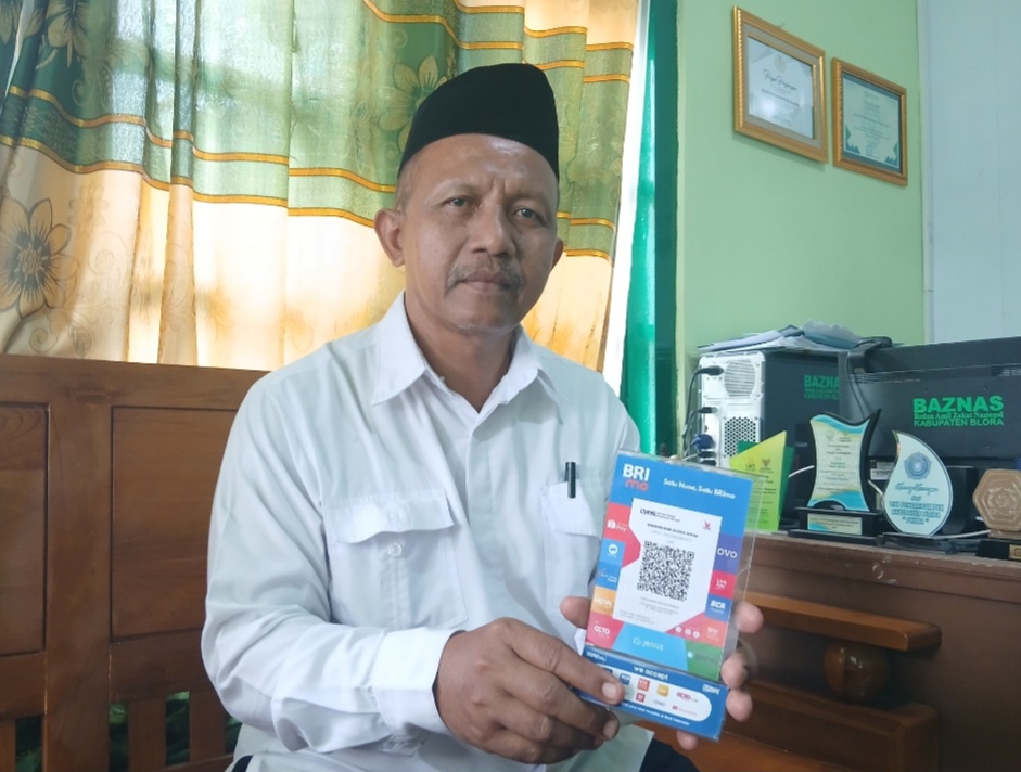 PEDULI: Ketua Baznas Kabupaten Blora Sutaat saat menunjukkan cara berdonasi bagi masyarakat yang hendak bersolidaritas kepada korban banjir di Sumatera.