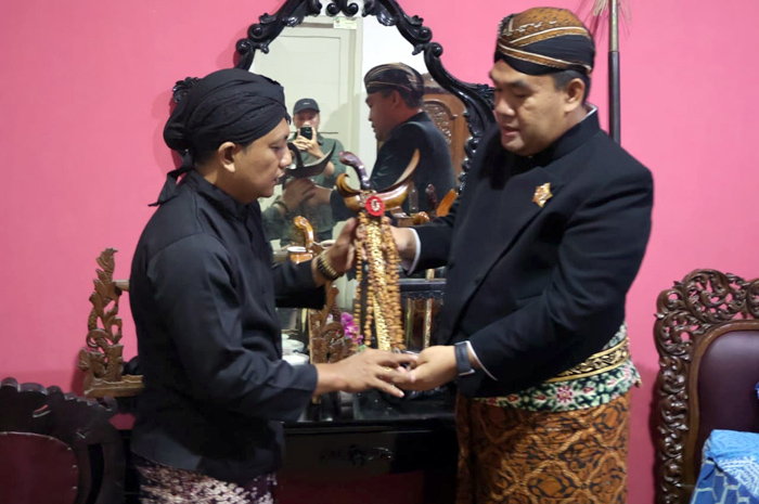 DIBERSIHKAN: Bupati Blora Arief Rohman (kanan) menyerahkan pusaka Pemerintah Kabupaten Blora Keris Kiai Bismo kepada panitia penjamasan untuk dijamas kemarin.