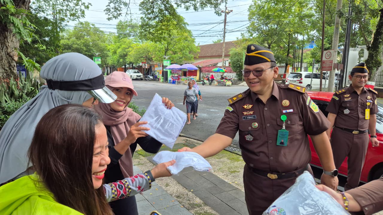 BAGIKAN KAOS &ndash; Anggota Jaksa Kejari Grobogan membagikan kaos korupsi kepada warga yang sedang berolahraga di alun-alun Purwodadi di hari anti korupsi, Selasa (9/12).