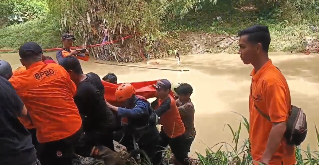 DUKA: Petugas gabungan saat mengangkat jenazah korban tenggelam di Sungai Lusi.