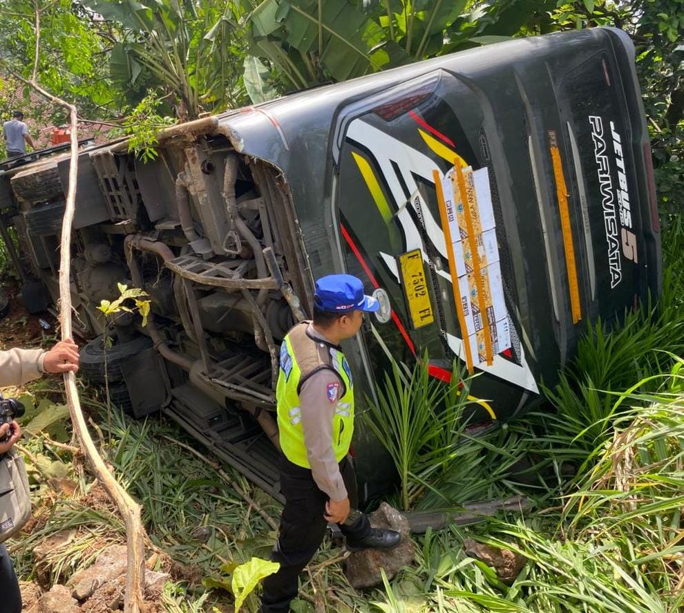 TERGULING: Polisi melintas di dekat bus yang terperosok di leter S Desa Terso.