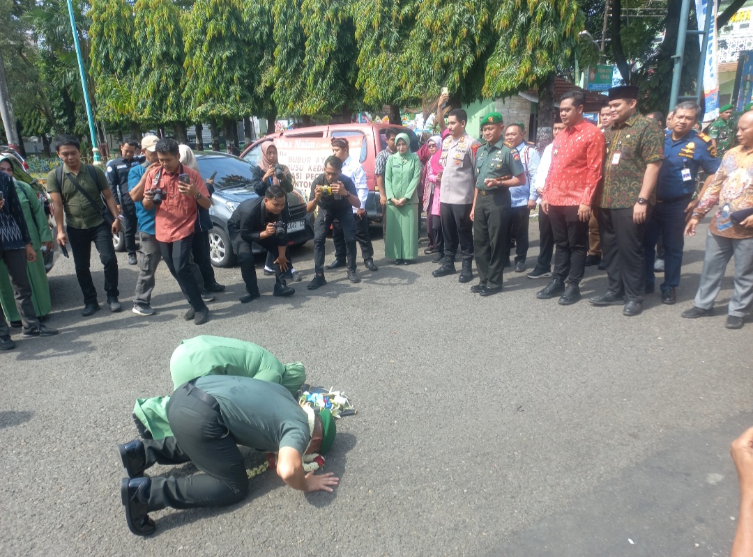 SAKRAL: Letkol Arm Khoirul Cahyadi beserta istri sujud syukur usai menyalami segenap prajurit, prosesi tersebut dilakukan di luar pintu gerbang Kodim 0719/Jepara.