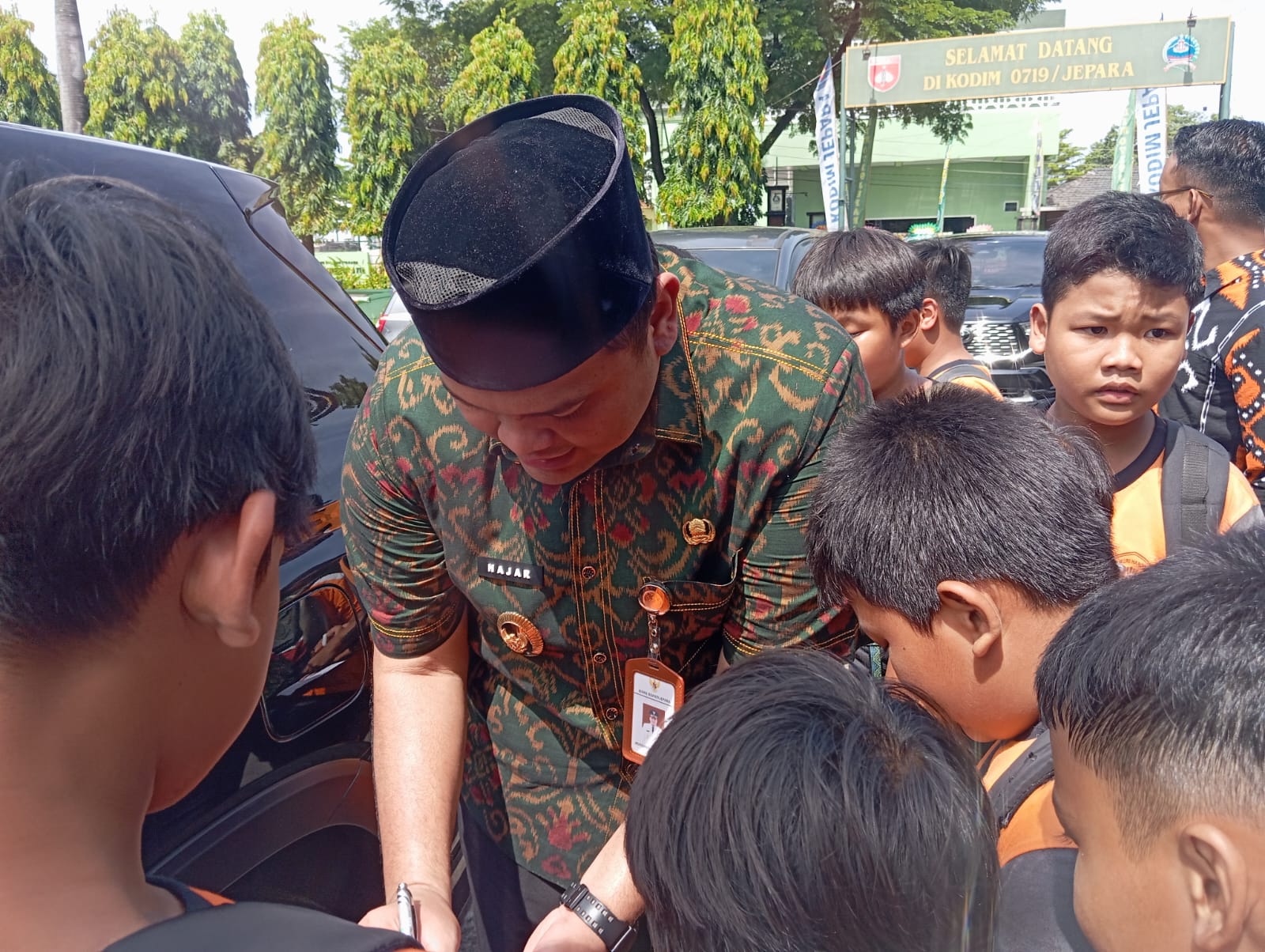 SABAR GUS: Gus Hajar melayani permintaan anak-anak tanda tangan di buku mereka.