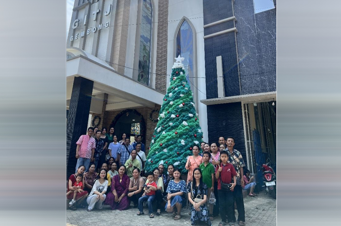BERKUMPUL: Jemaat GITJ Gembong foto bareng di depan pohon natal dari rafia di halaman gereja setempat belum lama ini.