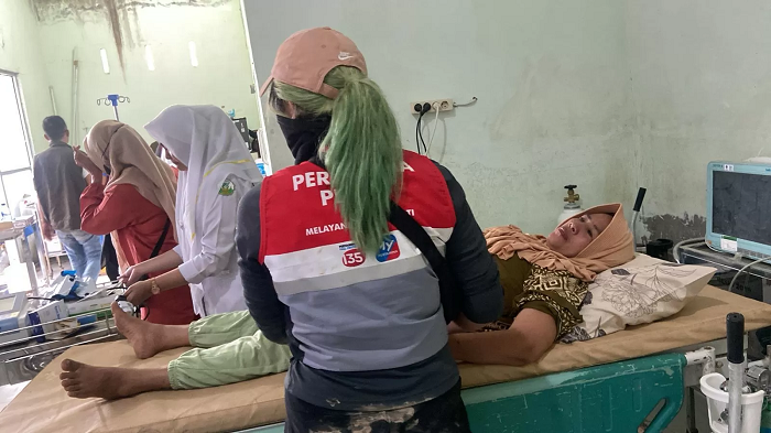 Relawan Pertamina Peduli mendampingi salah satu warga terdampak di Aceh Tamiang dalam perjalanan menuju rumah sakit karena kondisi darurat.