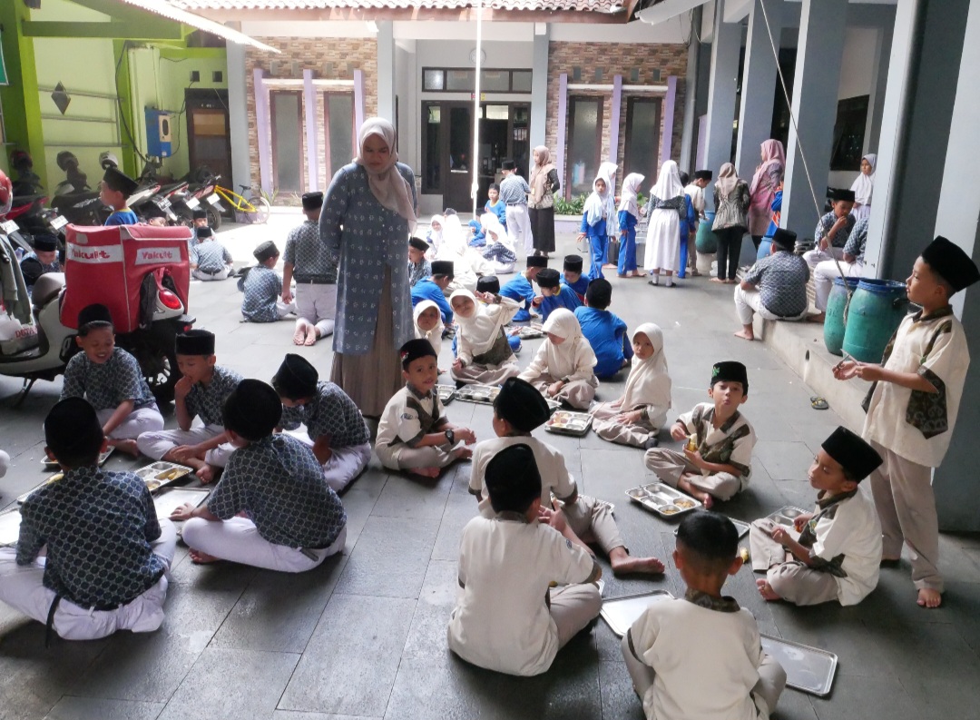 MONITORING: Guru SD Al Islam Pengkol tengah mengawasi siswa-siswi memakan menu MBG belum lama ini.