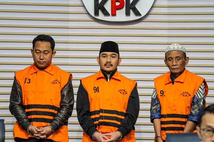 Bupati Bekasi Ade Kuswara Kunang (tengah) bersama ayahnya H.M. Kunang (kanan) dan pihak swasta Sarjan (kiri) dihadirkan saat konferensi pers penahanan usai terjaring OTT di Gedung Merah Putih KPK.