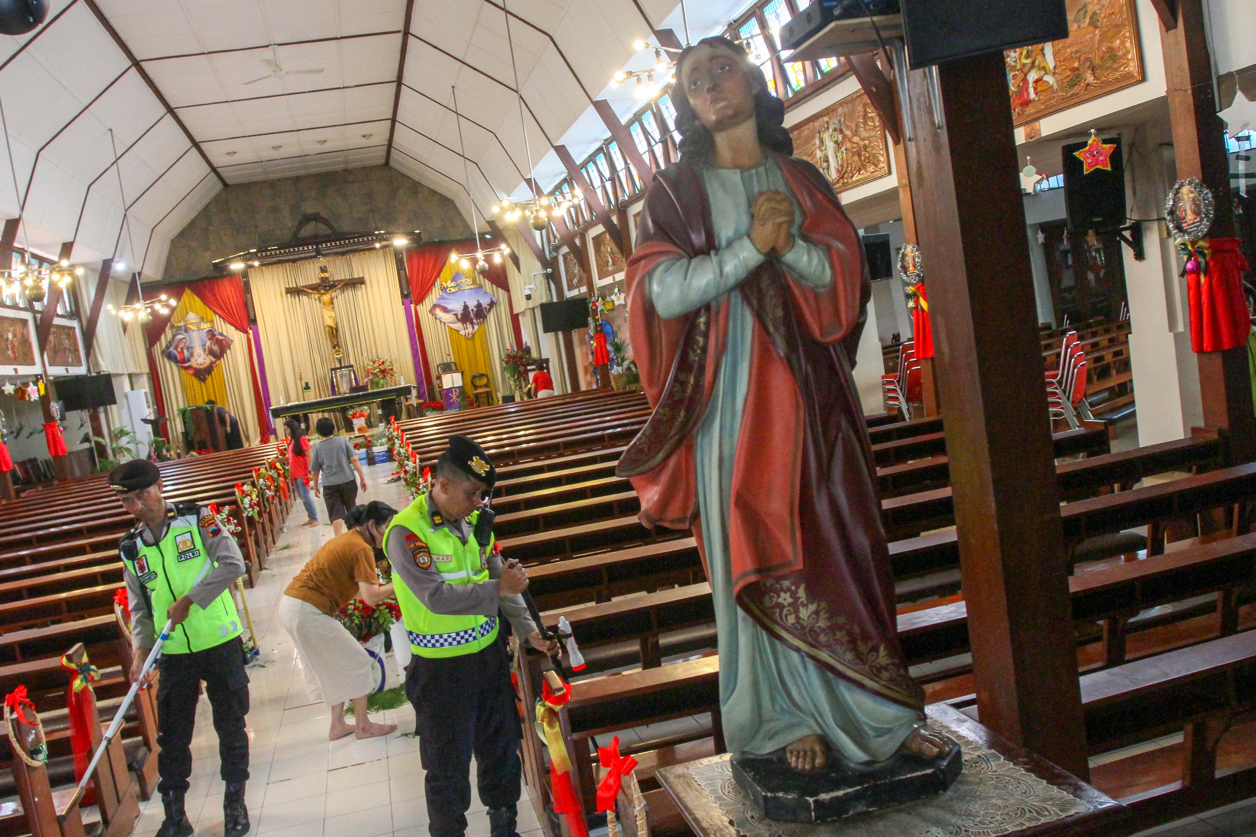 DIPERKETAT: Polisi melakukan pengecekan area Gereja Santo Yohanes Evangelista menjelang misa Natal.