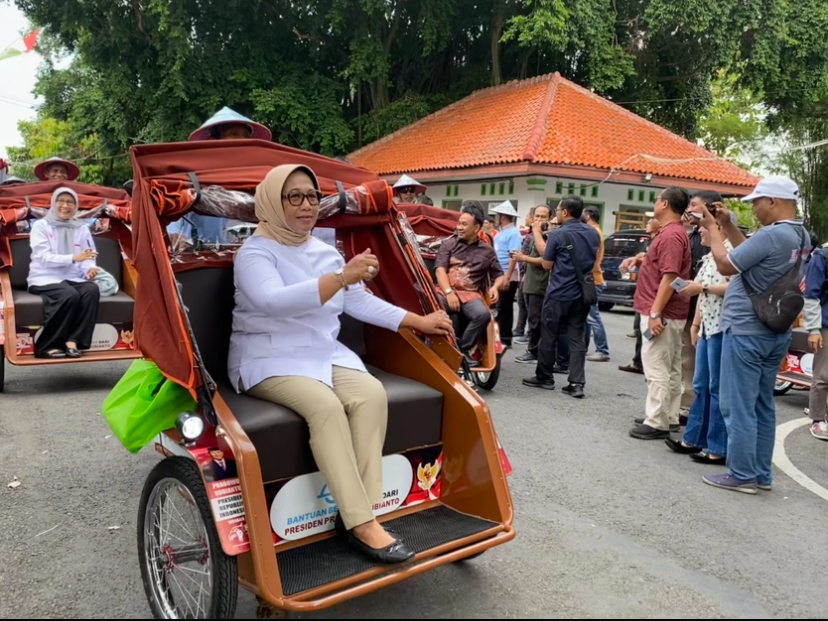 NAIK: Wakil Bupati Blora Sri Setyorini menaiki becak listrik pemberian Presiden Prabowo Subianto mengelilingi Alun-alun Blora