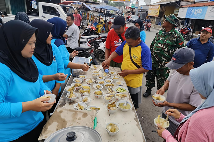 DIBAGI: Dapur MBG di Winong membagikan makan gratis kepada warga di pasar desa setempat akhir pekan lalu.