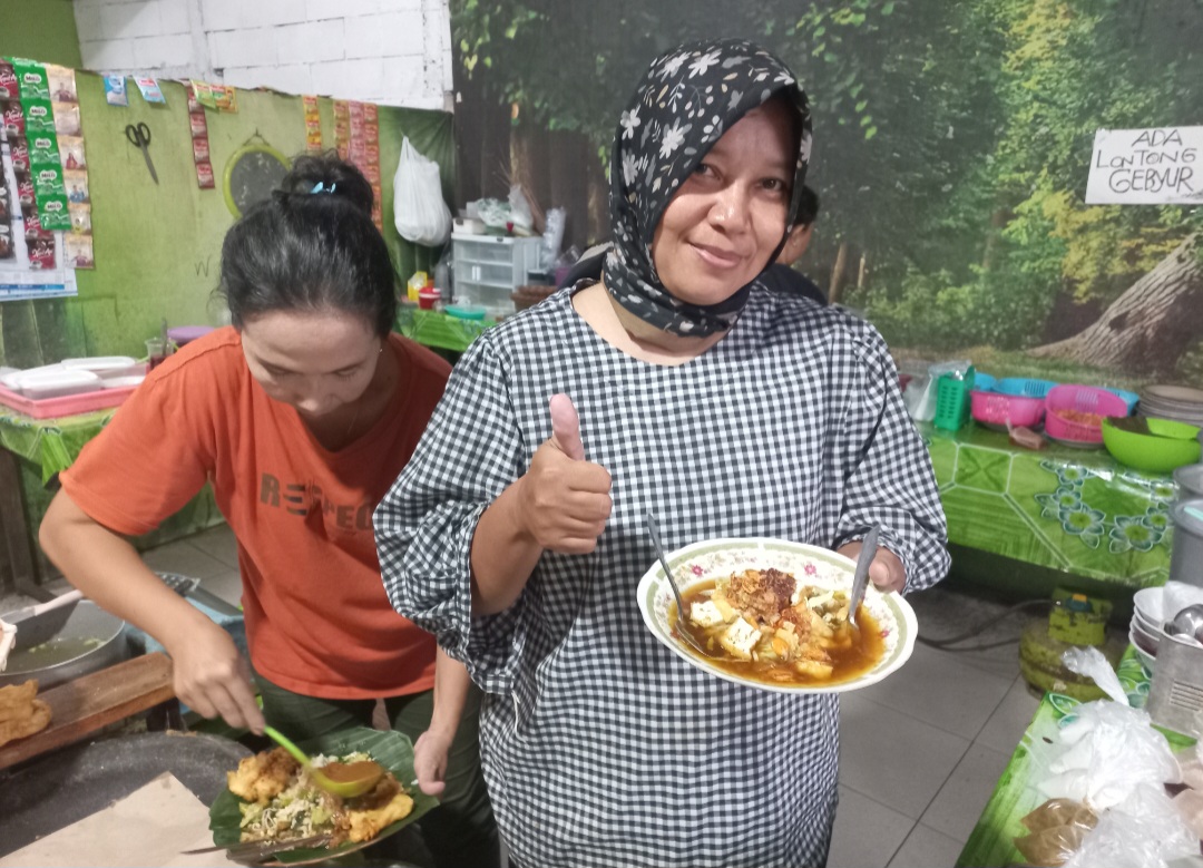 LEGENDARIS: Ningsih tengah menyajikan lontong gebyur pada pembeli.