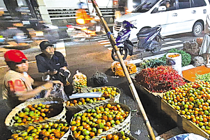 BERJUALAN DI JALAN: Aktivitas pedagang sayur di Pasar Bitingan malam hari selalu menjadi jujugan warga.