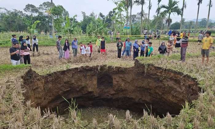 Warga sekitar mendekati sinkhole yang mendadak muncul di wilayah Kabupaten Lima Puluh Kota, Sumbar.