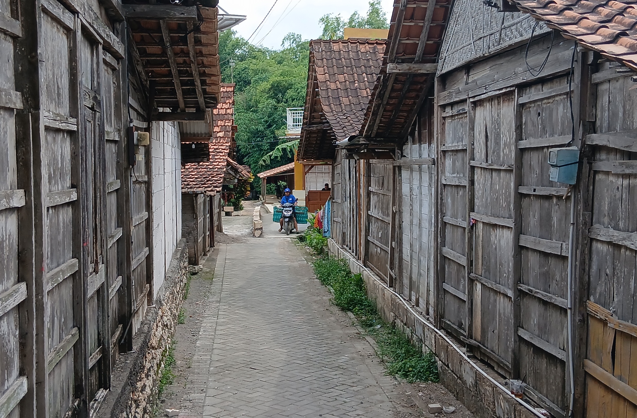 TERHALANG: Warga saat melintasi di jalan yang diblok pakai batu kumbung di wilayah RT 2 RW 3 Desa Kalangan Kecamatan Tunjungan.