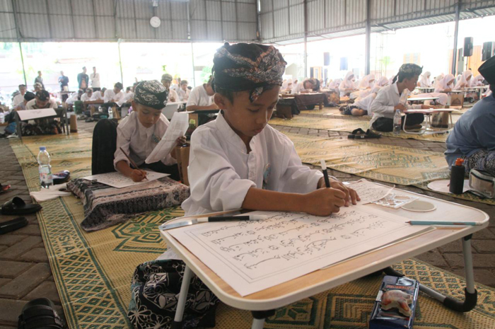 TELATEN: Sejumlah santri mengikuti lomba kaligrafi kemarin.