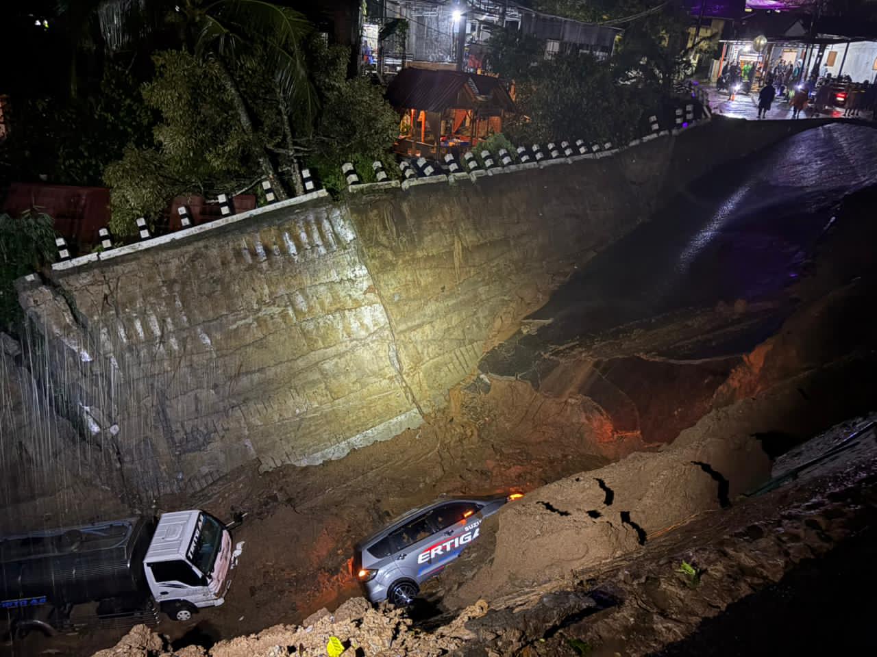 TERPEROSOK: Satu truk dan mini bus terperosok di jembatan di dekat Portal Colo