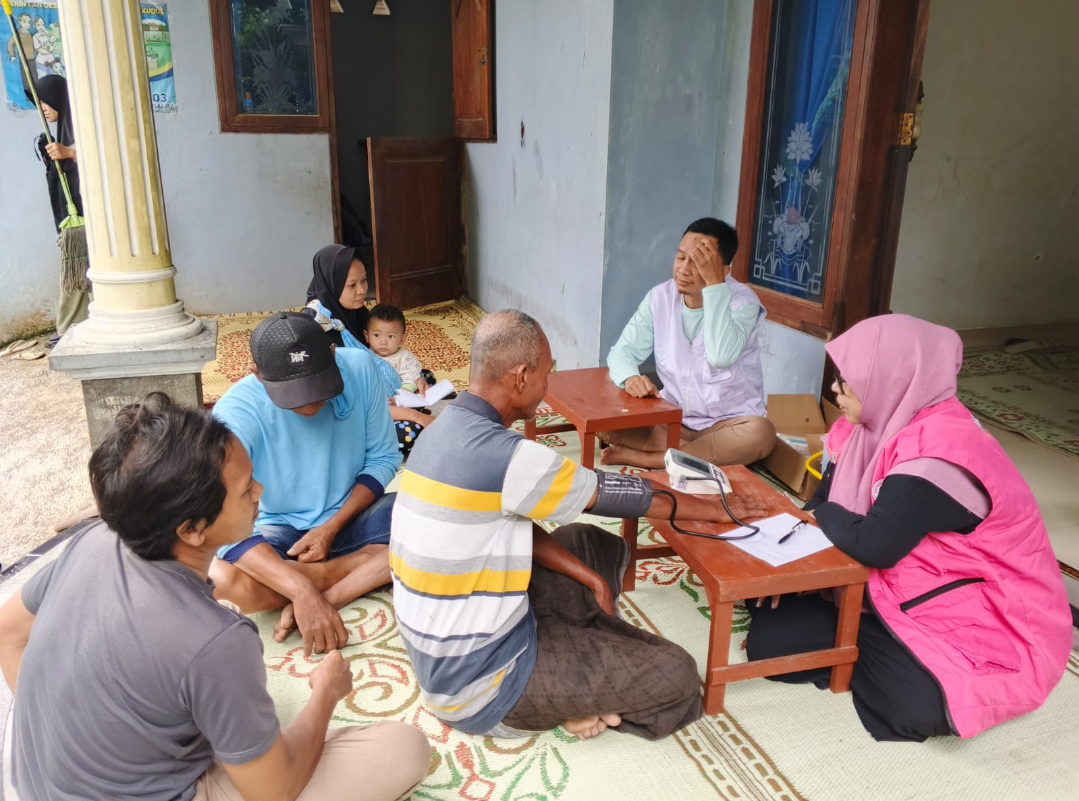 CEK KESEHATAN: Tim kesehatan sedang mengoperasikan alat pengukur tekanan darah kepada warga setempat menggunakan layanan kesehatan gratis pascabanjir, Minggu (11/1). (PEMDES JOJO UNTUK RADAR KUDUS)