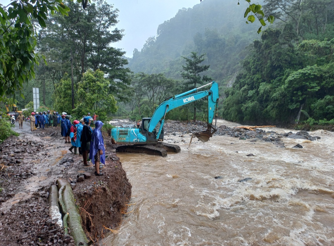 MEGATRON: Operator ekskavator tengah berupaya mengeruk bebatuan dari sungai supaya aliran sungai tidak menggerus badan jalan pada Senin (12/1).