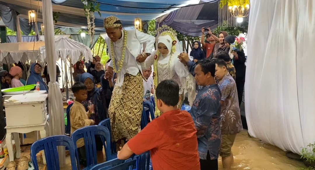 LANGKA: Prosesi pernikahan tetap digelar dalam kondisi banjir di Desa Kesambi, Senin (12/1). (ANDIKA TRISNA SAPUTRA/RADAR KUDUS)