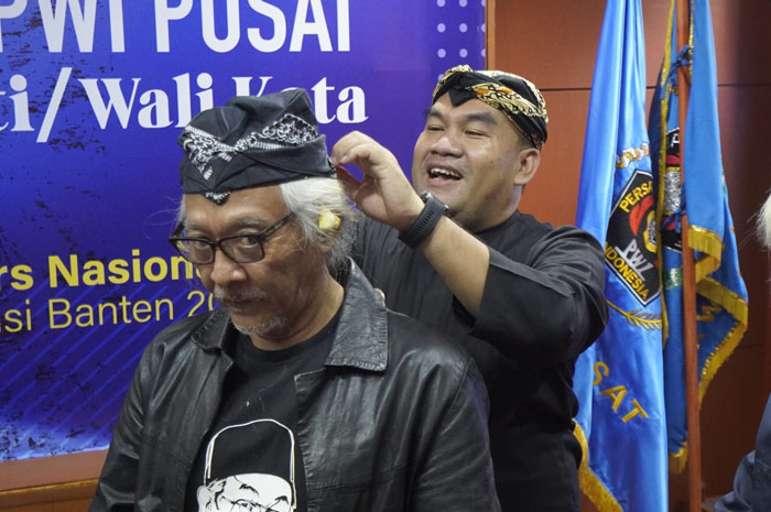 CERIA: Bupati Blora Arief Rohman (kanan) saat memasangkan udeng ke Sujiwo Tejo (salah satu juri).