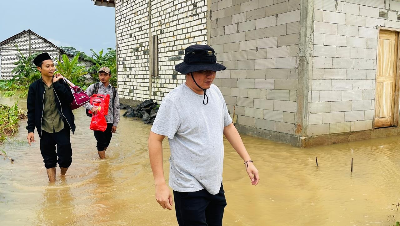 Kepala Desa Dukuhseti, Ahmad Rifai, menyusuri jalan desa yang terdampak banjir.