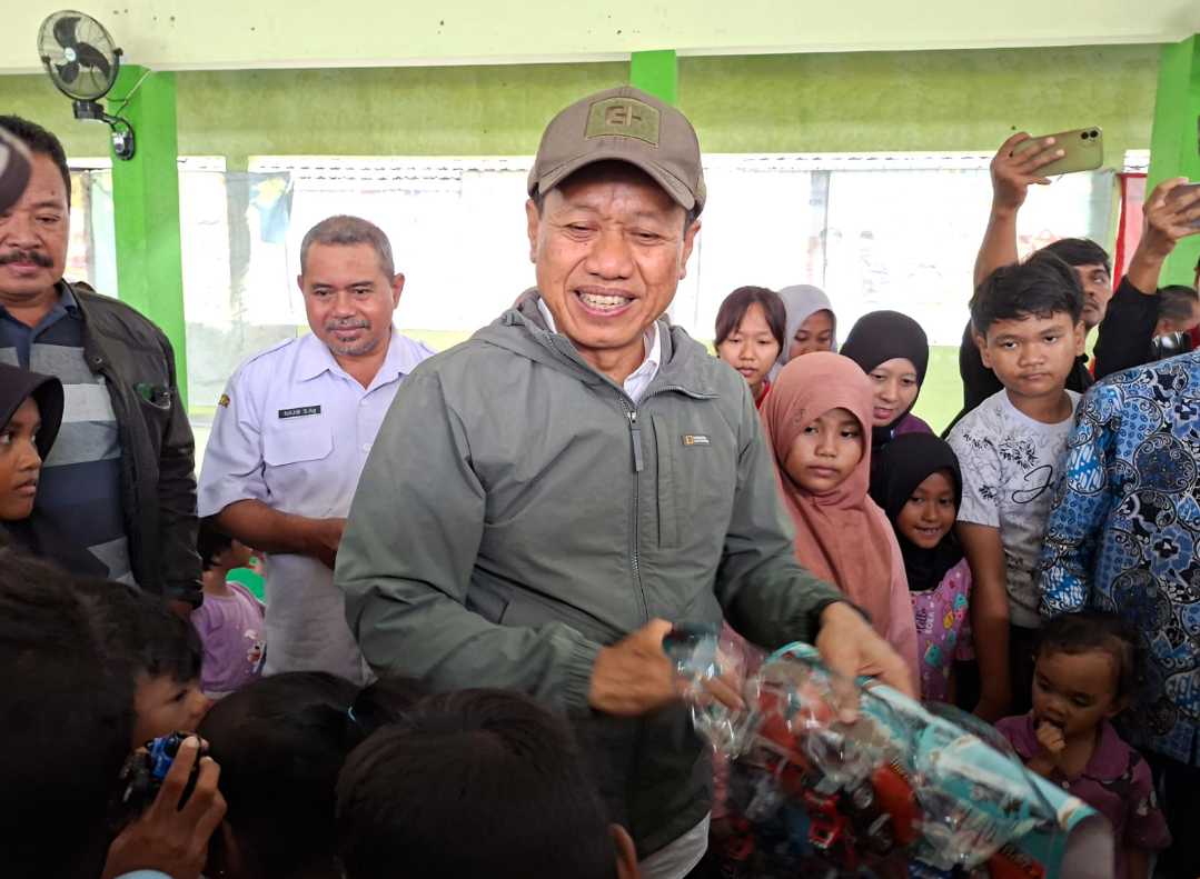 HIBUR: Bupati Kudus Sam&rsquo;ani Intakoris membagikan mainan kepada anak-anak penghuni posko pengungsian, Rabu (14/1). (ANDIKA TRISNA SAPUTRA/RADAR KUDUS)