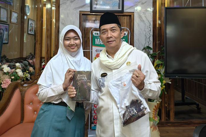 BIKIN BANGGA: Kepala MAN 2 Kudus, Ali Musyafak, berfoto dengan Bening Cita Maharsi, siswa kelas XI-11 Jurusan IPS MAN 2 Kudus sekaligus penulis novel "Rantai Altara".