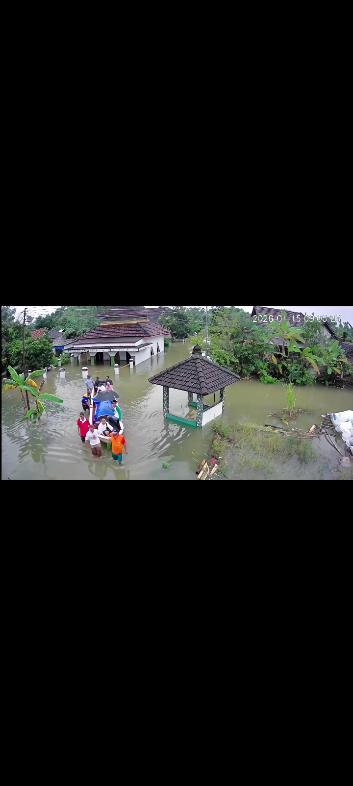 DIANTAR: Warga Desa Mintobasuki, Gabus hendak mengantarkan jenazah dengan menerjang banjir di desa setempat pada Kamis (15/1).