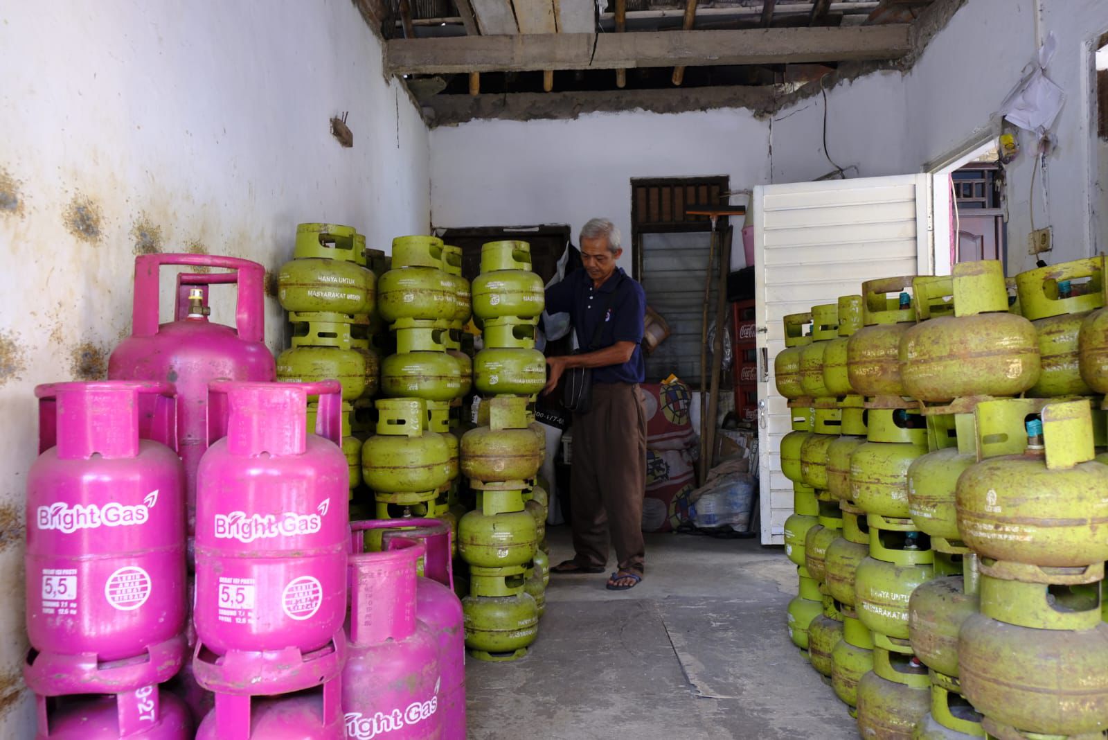 STOK AMAN: Pemilik pangkalan elpiji 3 Kg di Kudus saat merapikan dan menata tumpukan tabung gas.
