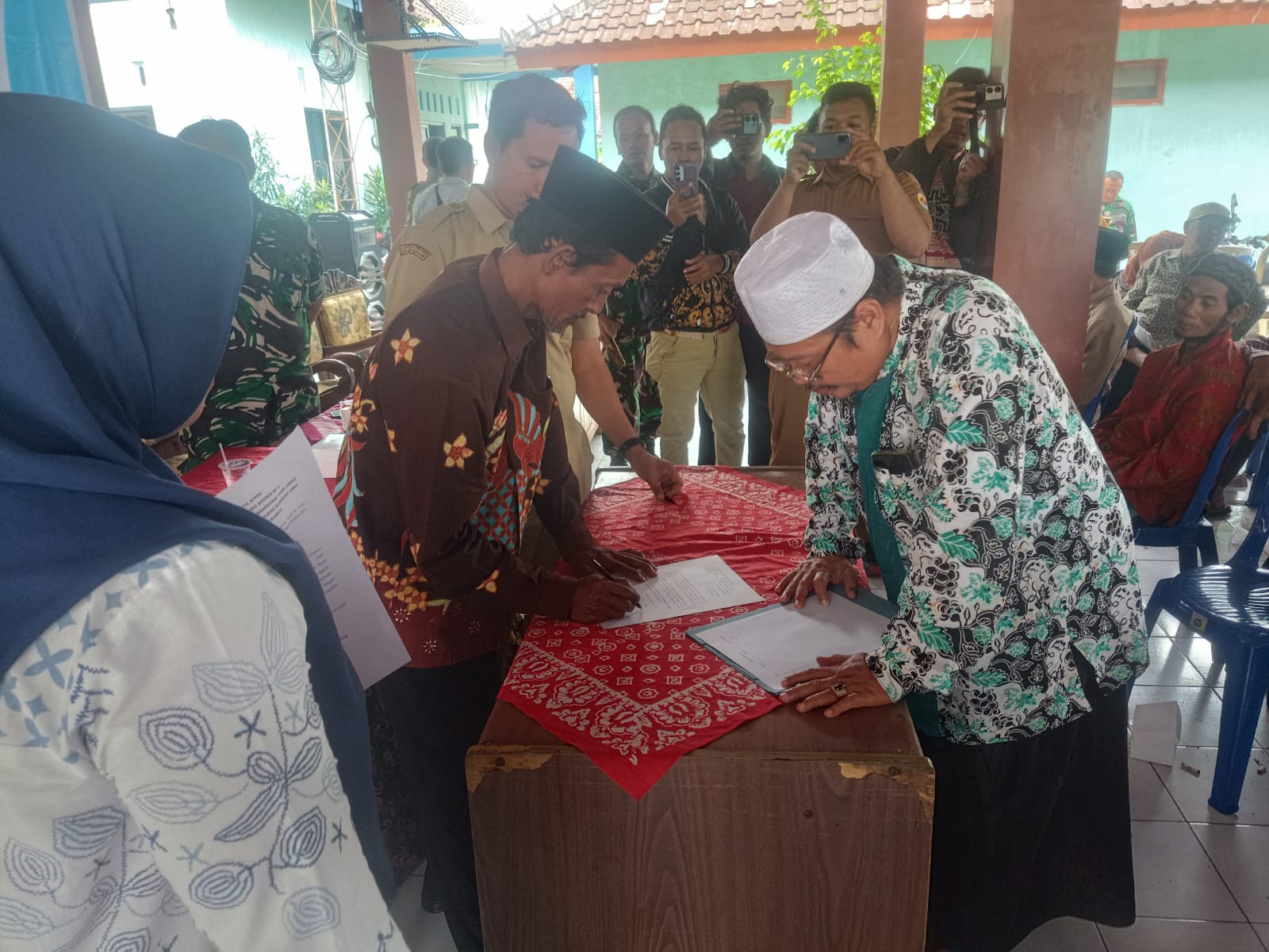 SEPAKATI BERSAMA &ndash; Perwakilan bersama dengan perangkat Desa lakukan Musdesus pembahasan pembangunan KDMP di lapangan Desa setempat.