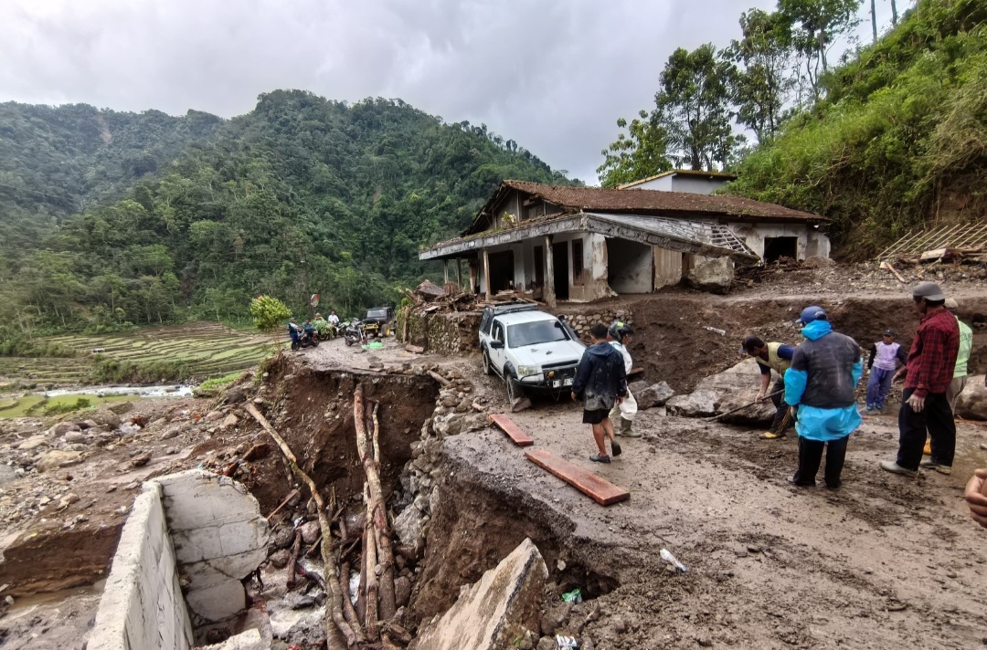 BUKA AKSES: Mobil 4x4 milik relawan berupaya menyingkirkan batu dari area jalan.