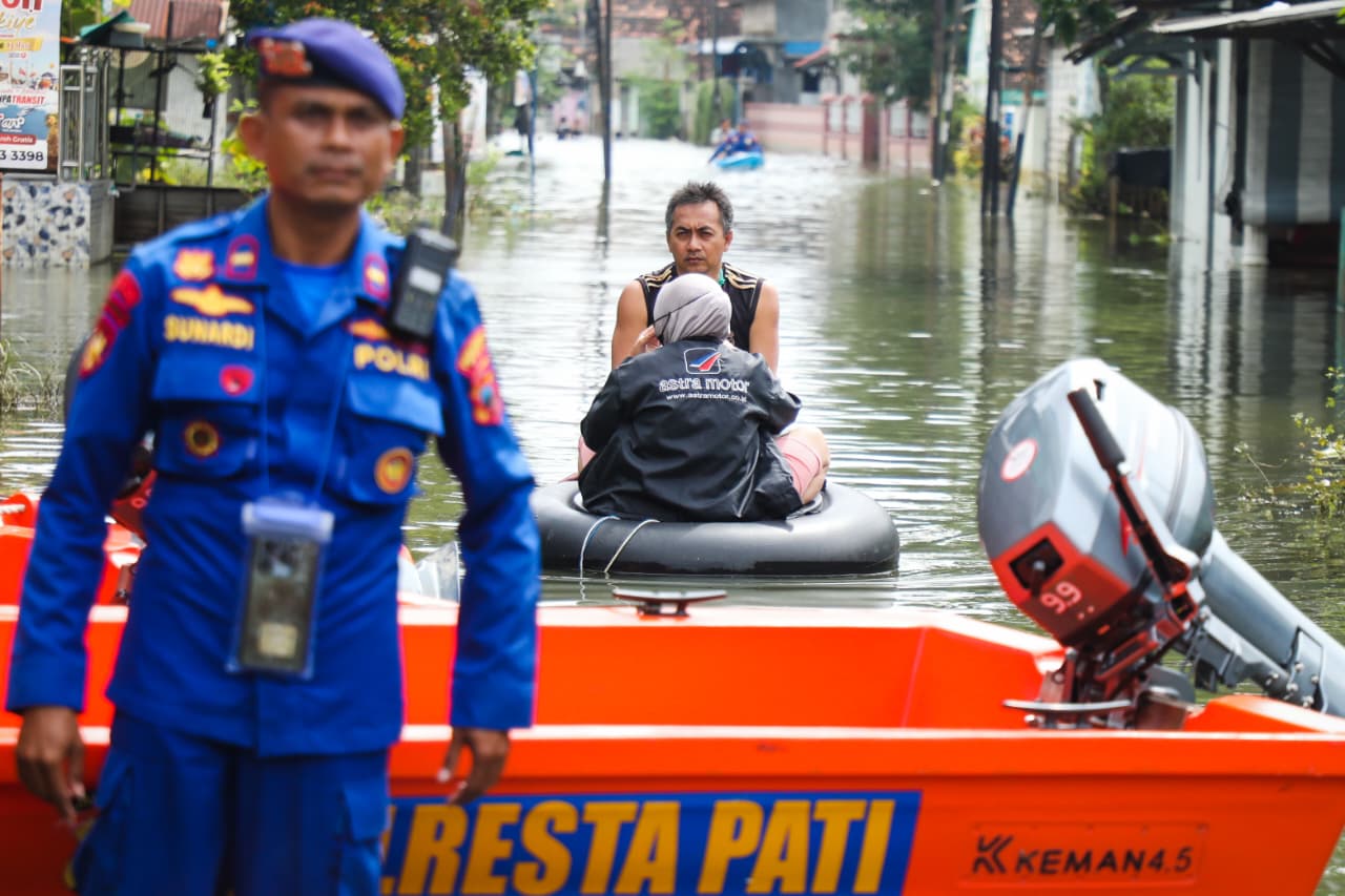 BERJUANG: Terlihat pengungsi menolong keluarganya dari banjir Pati.