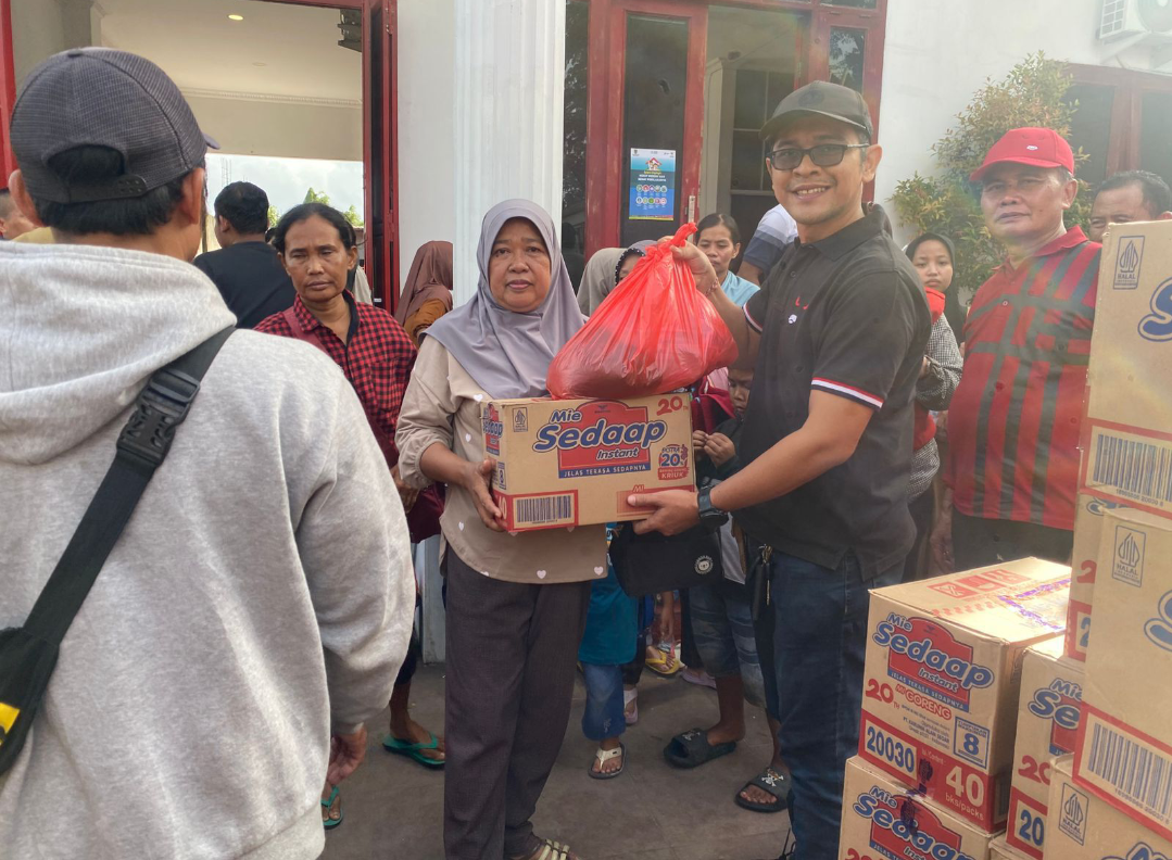 PULANG: Ketua DPC PDI Perjuangan Kudus, Achmad Yusuf Roni (topi hitam) membagikan bantuan sembako untuk pengungsi banjir saat meninggalkan pengungsian, Sabtu (24/1). (DPC PDIP KUDUS UNTUK RADAR KUDUS)