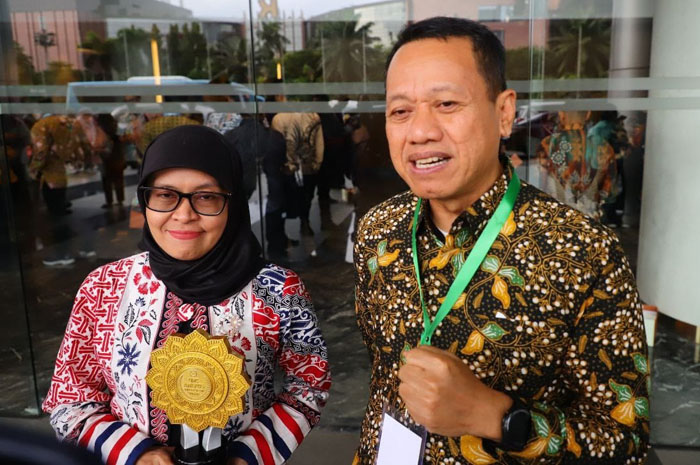 TERIMA PENGHARGAAN: Bupati Kudus Sam&rsquo;ani Intakoris (kanan) bersama kepala BPJS Kesehatan Cabang Kudus dr. Heni Riswanti sambil memegang piala penghargaan UHC Award 2026.