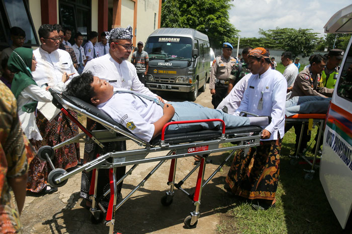 PENANGANAN: Petugas melakukan evakuasi siswa SMA 2 Kudus yang diduga keracunan MBG.