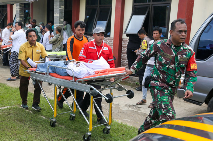 UPAYA PENANGANAN: Tim medis dan TNI mengevakusasi siswa yang mengalami dugaan keracunan MBG.