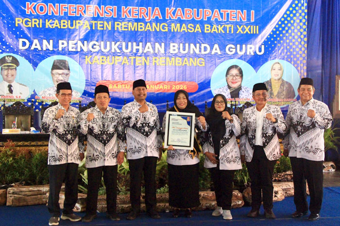 DIKUKUHKAN: Musringah Harno menerima sertifikat penghargaan setelah dinobatkan Bunda Guru dari Ketua PGRI Rembang, Isti Choma Wati, dalam agenda konferensi kerja Kabupaten I PGRI Kabupaten di pendapa