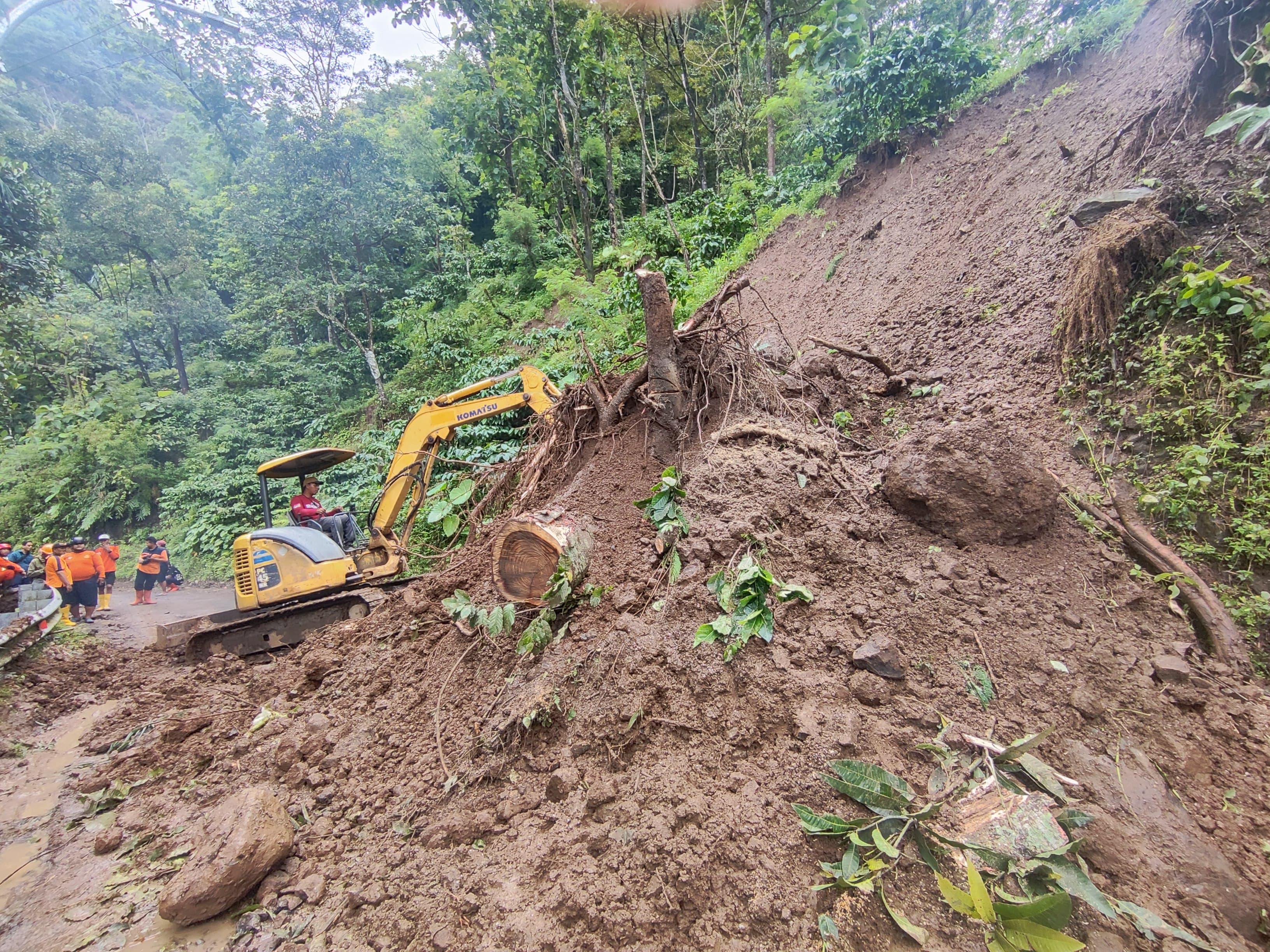 GERAK CEPAT: Petugas melakukan pembersiahan material tanah longsor.