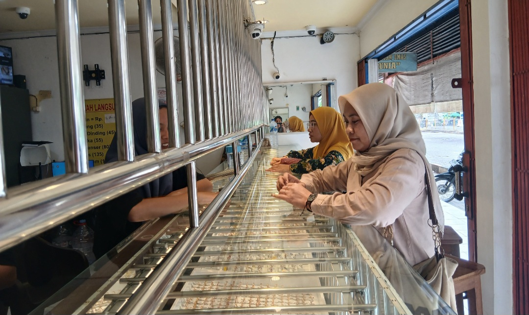 ANTUSIAS: Seorang pembeli saat memilah emas di sebuah toko emas di pasar Sidomakmur Blora.