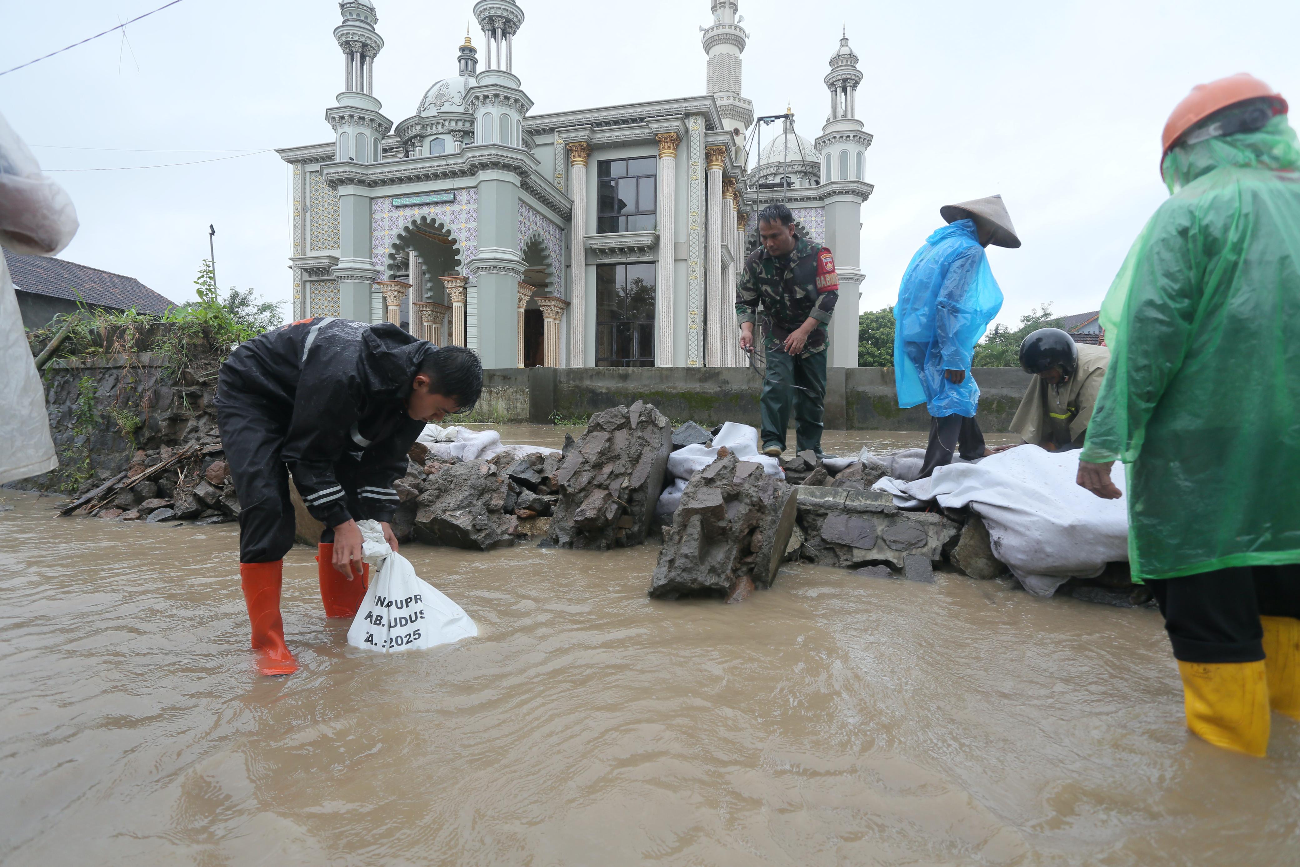 DITANGANI: Tim gabungan melakukan penambalan tanggul jebol di Desa Pladen.