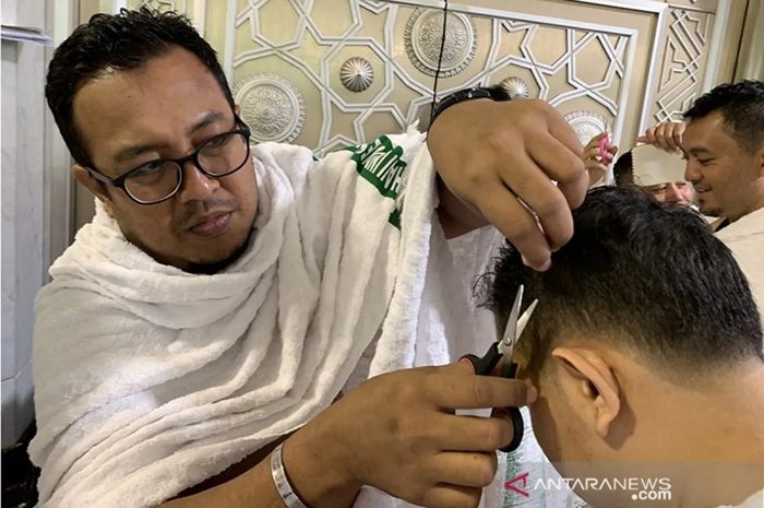 Petugas haji melakukan tahalul atau mencukur rambut setelah selesai melakukan umroh di Mekkah.
