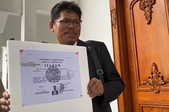 Pengamat kebijakan publik Bonatua Silalahi memamerkan salinan ijazah Presiden ke-7 RI Joko Widodo (Jokowi) di halaman Kantor Komisi Pemilihan Umum (KPU) RI, Jakarta, Senin (9/2). (Istimewa)