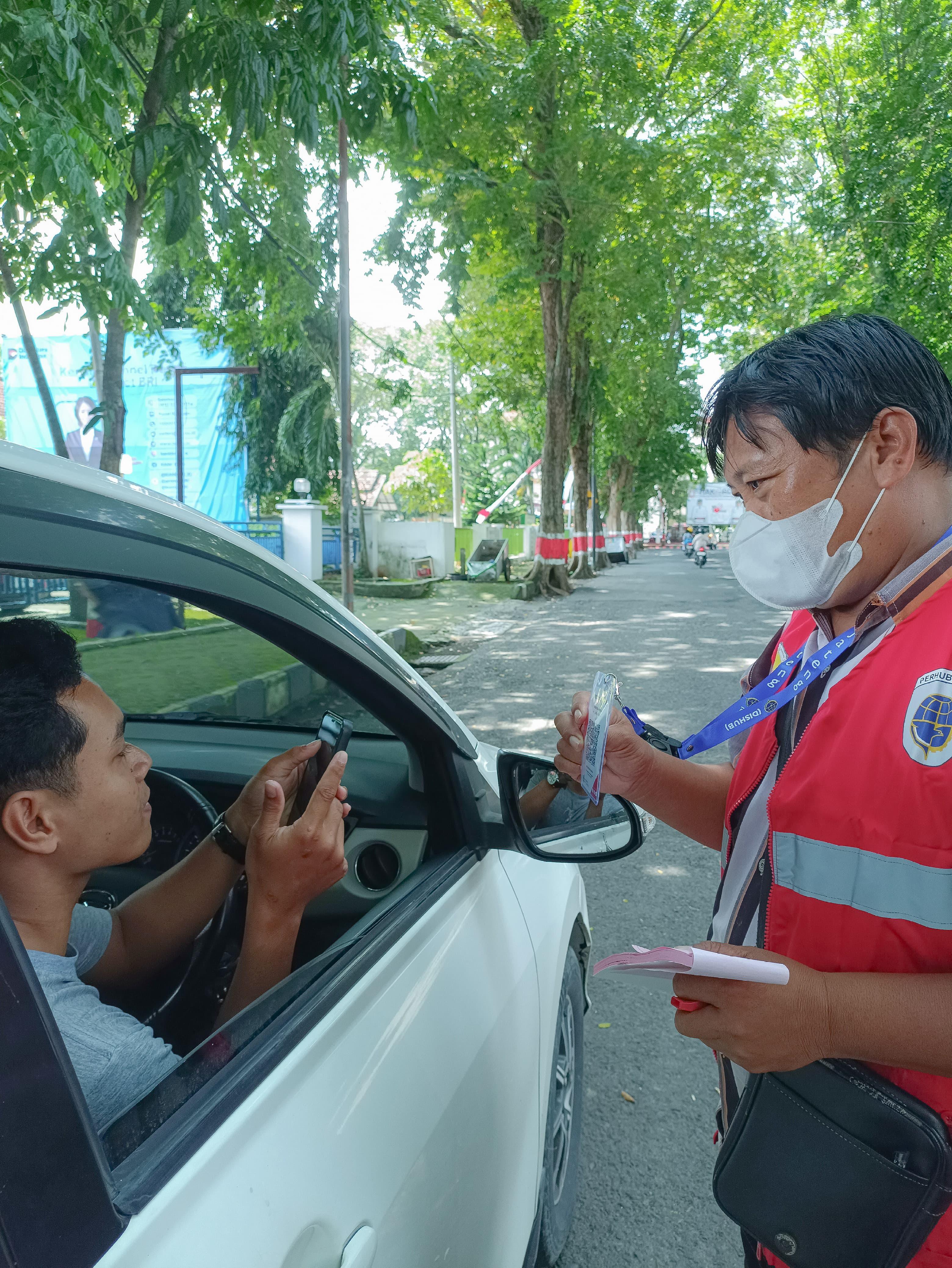 DIGITALISASI: jukir saat menunjukkan QRIS ke pengguna parkir di Alun-Alun Purwodadi.