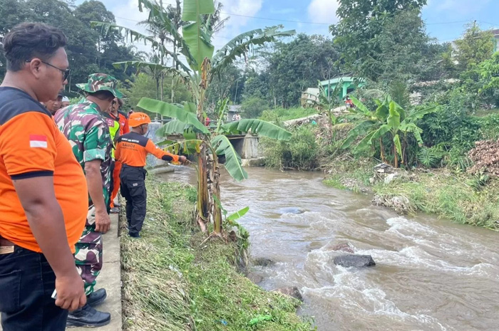 Anggota tim SAR gabungan saat melakukan pencarian korban pengendara motor yang terseret arus sungai di Kalimalang Mijen