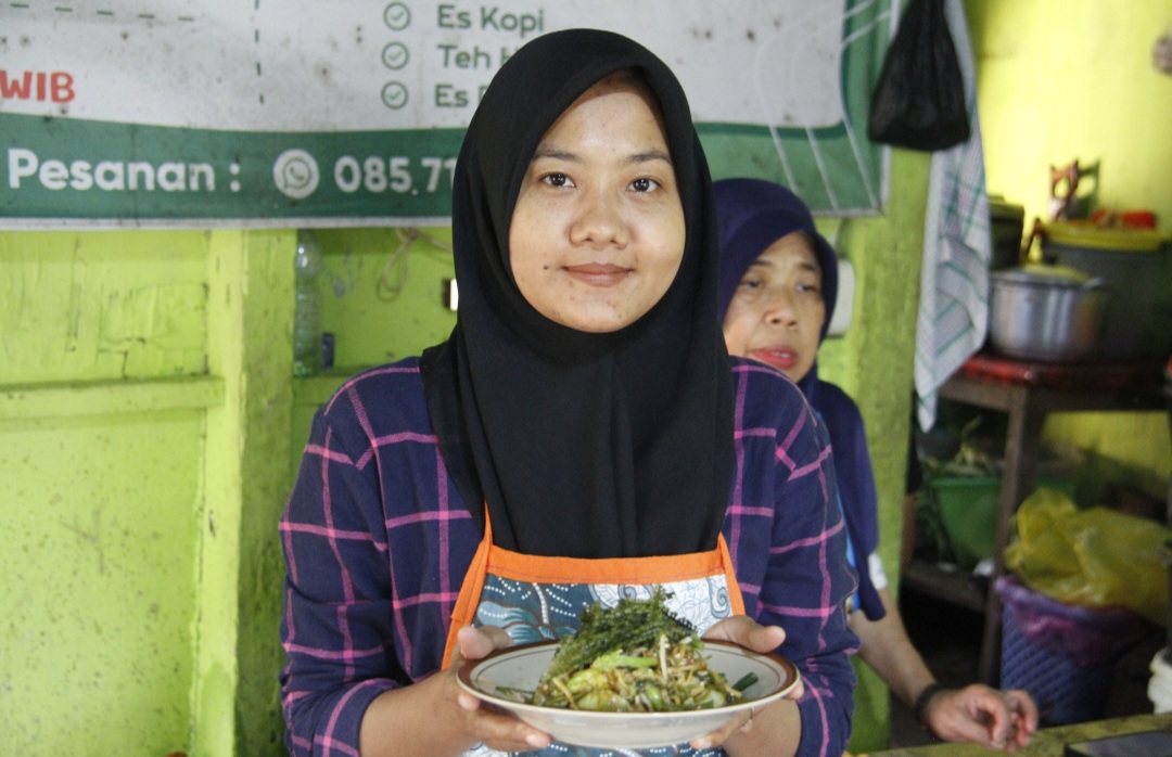 CITARASA KHAS: Yuli (31) menyajikan seporsi menu lontong sambal petis pada Jumat (13/2).