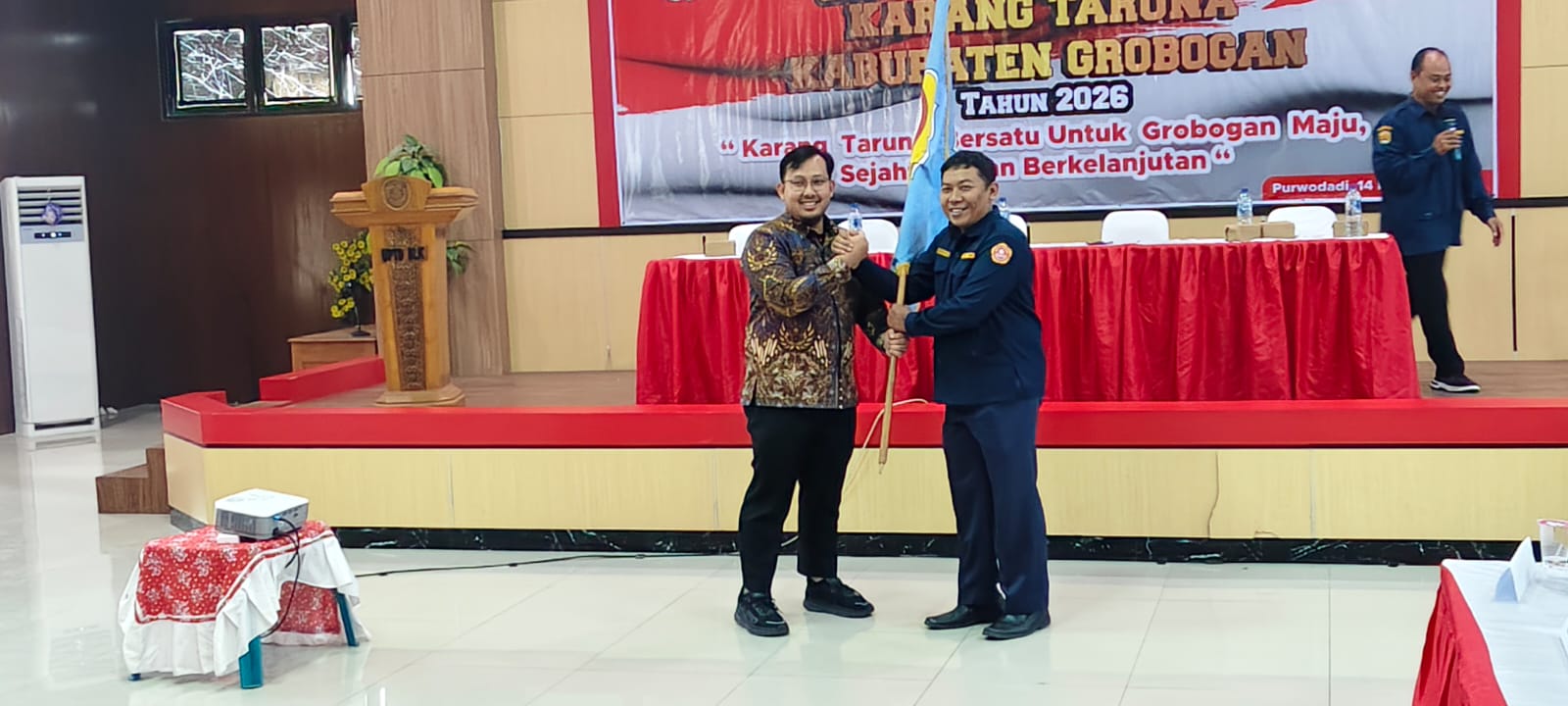 ETAFET KEPEMIMPINAN &ndash; Kurniawan menyerahkan bendera Karangtaruna kepada Miftahuddin Alif Sugeng Ketua Karangtaruna terpilih periode 2026-2031 di gedung BLK Purwodadi, Sabtu (14/2)